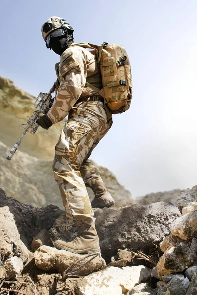 Soldat du désert posant sur une montagne de pierre . — Photo