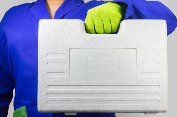 Trabalhador em roupa azul segurando caixa de ferramentas de plástico . — Fotografia de Stock