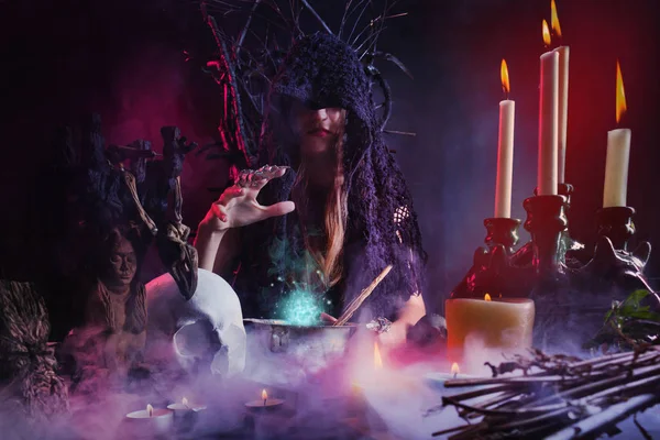 女魔女座っていますテーブル鋳造呪文. — ストック写真