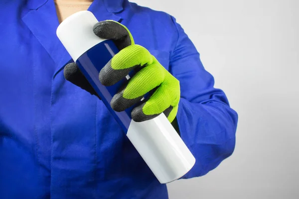 Pracownik w niebieskim stroju i butelce z rękawiczkami. — Zdjęcie stockowe