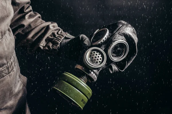 Zdjęcie Stalkera Trzymającego Sowiecką Maskę Gazową Podczas Deszczu Czarnym Tle — Zdjęcie stockowe
