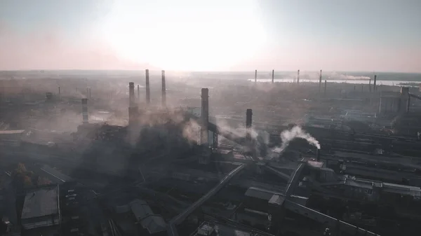 Çelik endüstrisi, ağır sanayi sanayi sanayi bölgesi, dumanlı boru hattı çeliği. Arka planda gün batımı ve bulutlu gökyüzü. Mordor.