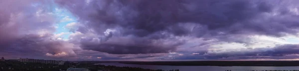 purple sunset with clouds over the city. sky panorama with colorful clouds for wallpaper design. dramatic cloud sky