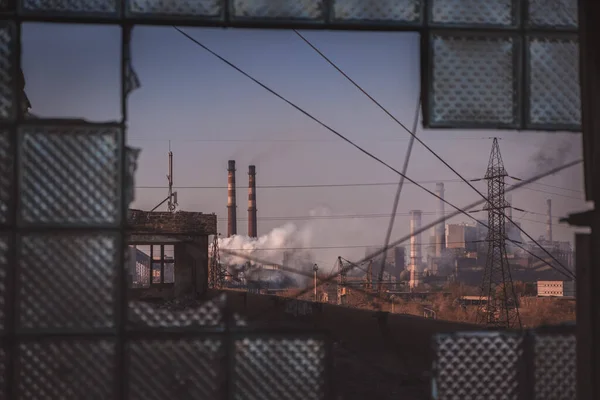 Lugar abandonado con antecedentes industriales. Vista de la zona industrial en tuberías con humo —  Fotos de Stock