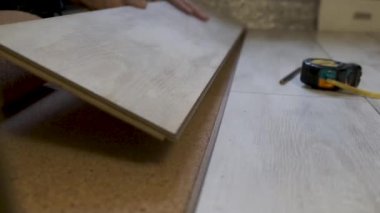 Bir evde döşeme kaplaması yapan bir adam.