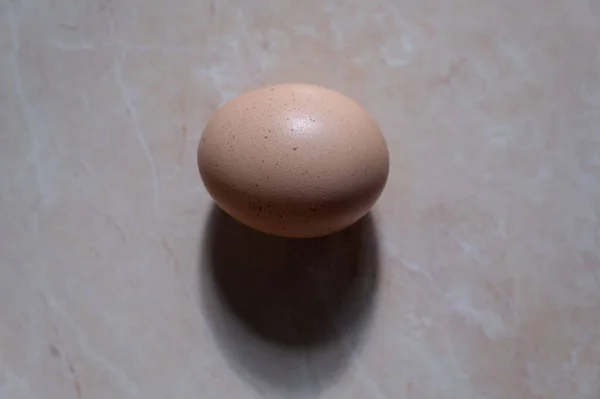 Одно куриное яйцо на коричневом фоне. ингредиент для завтрака — стоковое фото