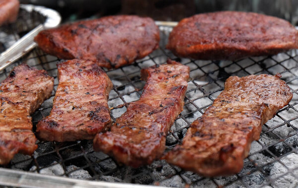 Barbecue in UK urban house garden in bright sun and warm weather.