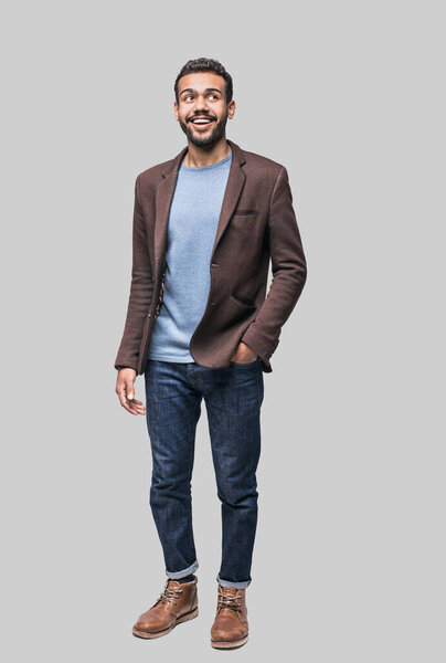 Full length studio portrait of handsome smiling young man isolated on gray background