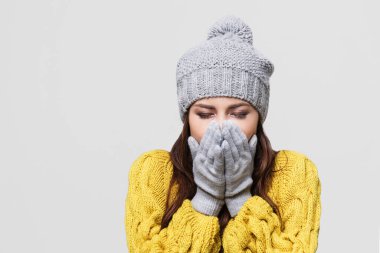 Kışın hasta kız, gri arka planda izole edilmiş.