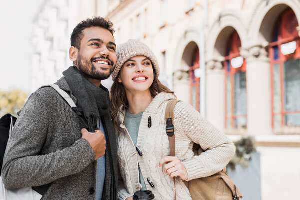 Beautiful happy couple autumn portrait. Young joyful smiling woman and man in a city in winter. Love, travel, tourism, students concept