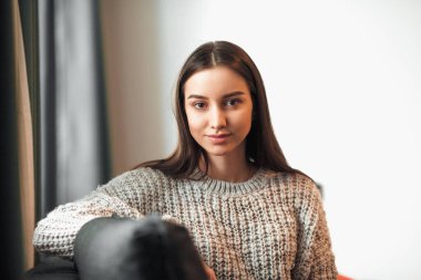 Genç bayan oturma odasındaki kanepede dinleniyor. Günlük tarz kapalı çekim.