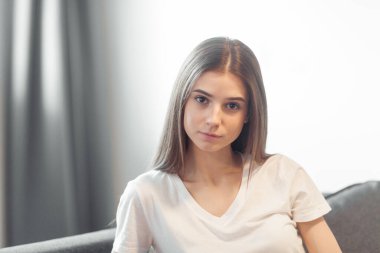 Genç bayan oturma odasındaki kanepede dinleniyor. Günlük tarz kapalı çekim.