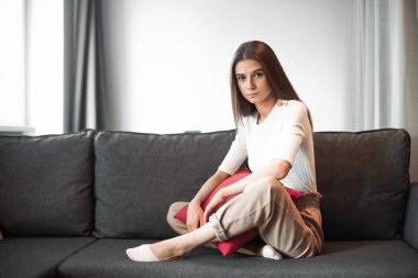 Genç bayan oturma odasındaki kanepede dinleniyor. Günlük tarz kapalı çekim.