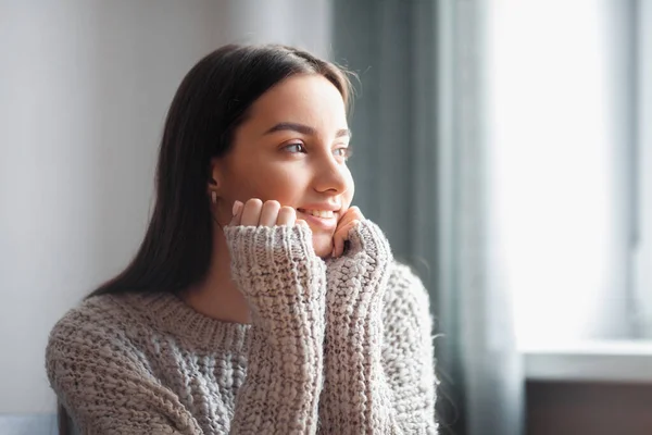 Beautiful young woman portrait behind window. Attractive caucasian model girl. Soft sun light. Sunrise or sunset.