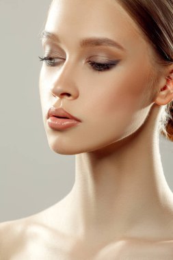 Güzel bir kadın stüdyo resmine yakından bakıyor. Genç ve çekici bir kız. Mükemmel cilt.