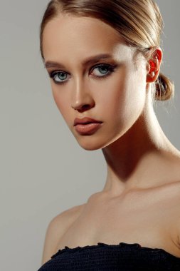 Güzel bir kadın stüdyo resmine yakından bakıyor. Genç ve çekici bir kız. Mükemmel cilt.