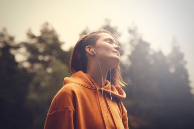 Kulaklıklı güzel bir kız. Hipster kadın açık hava portresi