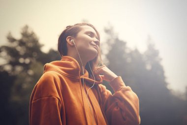 Parktaki hippi çekici kız kulaklık kullanıyor. Müzik dinleyen güzel bir kadın