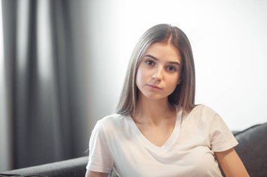 Genç bayan oturma odasındaki kanepede dinleniyor. Günlük tarz kapalı çekim.