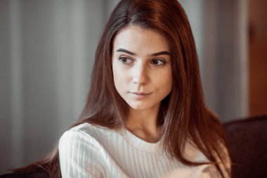 Genç bayan oturma odasındaki kanepede dinleniyor. Günlük tarz kapalı çekim.