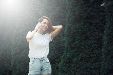 Cep telefonu kullanan genç bir kadın. Sıradan hippi kız sokak portresi