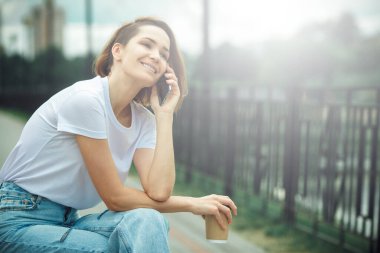 Cep telefonu kullanan genç bir kadın. Sıradan hippi kız sokak portresi