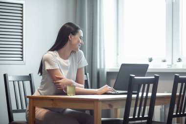 Işık odasında bilgisayarla çalışan bir kız. Modern iç mekanlarda sosyal ağda kadın sohbeti