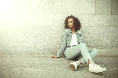 Güneşli şehir sokağındaki mutlu melez kız. Moda kadın portresi