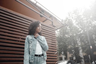Güneşli şehir sokağındaki mutlu melez kız. Moda kadın portresi