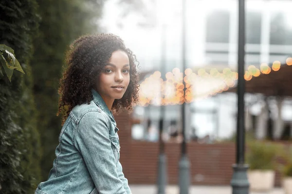 Güneşli şehir sokağındaki mutlu melez kız. Moda kadın portresi