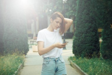 Cep telefonu kullanan genç bir kadın. Sıradan hippi kız sokak portresi