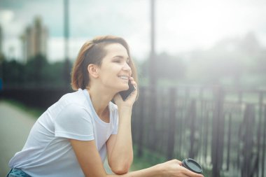 Cep telefonu kullanan genç bir kadın. Sıradan hippi kız sokak portresi