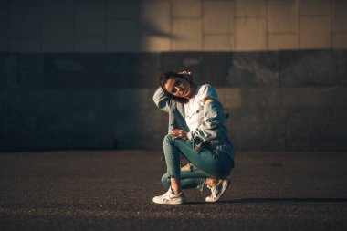 Moda kadını portresi. Genç, güzel, modaya uygun bir kız. Güneşli yaz şehri sokağı.