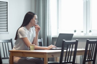 Işık odasında bilgisayarla çalışan bir kız. Modern iç mekanlarda sosyal ağda kadın sohbeti