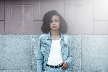 Denim stili melez kız portresi. Yaz şehrinde yürüyen hippi.