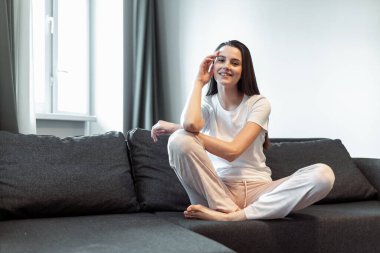 Genç bayan oturma odasındaki kanepede dinleniyor. Günlük tarz kapalı çekim.