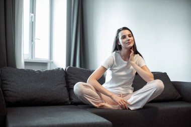 Genç bayan oturma odasındaki kanepede dinleniyor. Günlük tarz kapalı çekim.