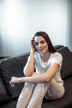 Genç bayan oturma odasındaki kanepede dinleniyor. Günlük tarz kapalı çekim.