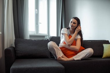 Genç bayan oturma odasındaki kanepede dinleniyor. Günlük tarz kapalı çekim.