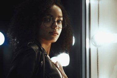 Genç, kıvırcık, Afro-Amerikan kızın portresi. Gece şehir ışıkları. Neon aydınlatması
