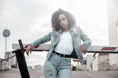 Siyah, genç ve güzel bir kız dışarıda dinleniyor. Sokak hipster portresi. Yürüyen öğrenci kadın.