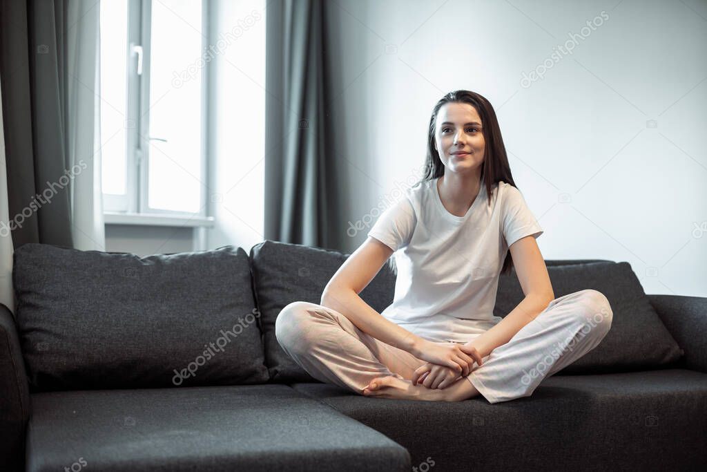 Young woman pretty relaxing on couch in living room. Casual style indoor shoot