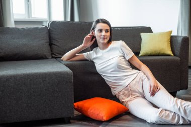 Genç bayan oturma odasındaki kanepede dinleniyor. Günlük tarz kapalı çekim.