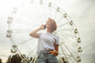 Cep telefonu kullanan genç bir kadın. Sıradan hippi kız sokak portresi