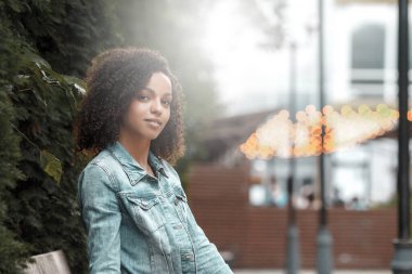 Denim stili melez kız portresi. Yaz şehrinde yürüyen hippi.