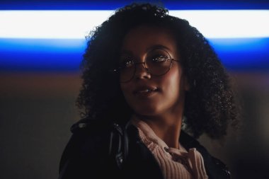 Genç, kıvırcık, Afro-Amerikan kızın portresi. Gece şehir ışıkları. Neon aydınlatması