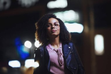 Genç, kıvırcık, Afro-Amerikan kızın portresi. Gece şehir ışıkları. Neon aydınlatması