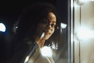 Genç, kıvırcık, Afro-Amerikan kızın portresi. Gece şehir ışıkları. Neon aydınlatması