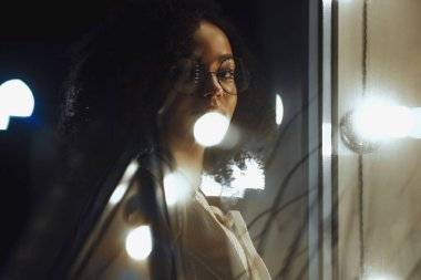 Genç, kıvırcık, Afro-Amerikan kızın portresi. Gece şehir ışıkları. Neon aydınlatması