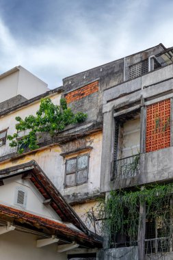 Yıpranmış şehir binası, aşırı gelişmiş yeşillik, açık şehir manzarası..